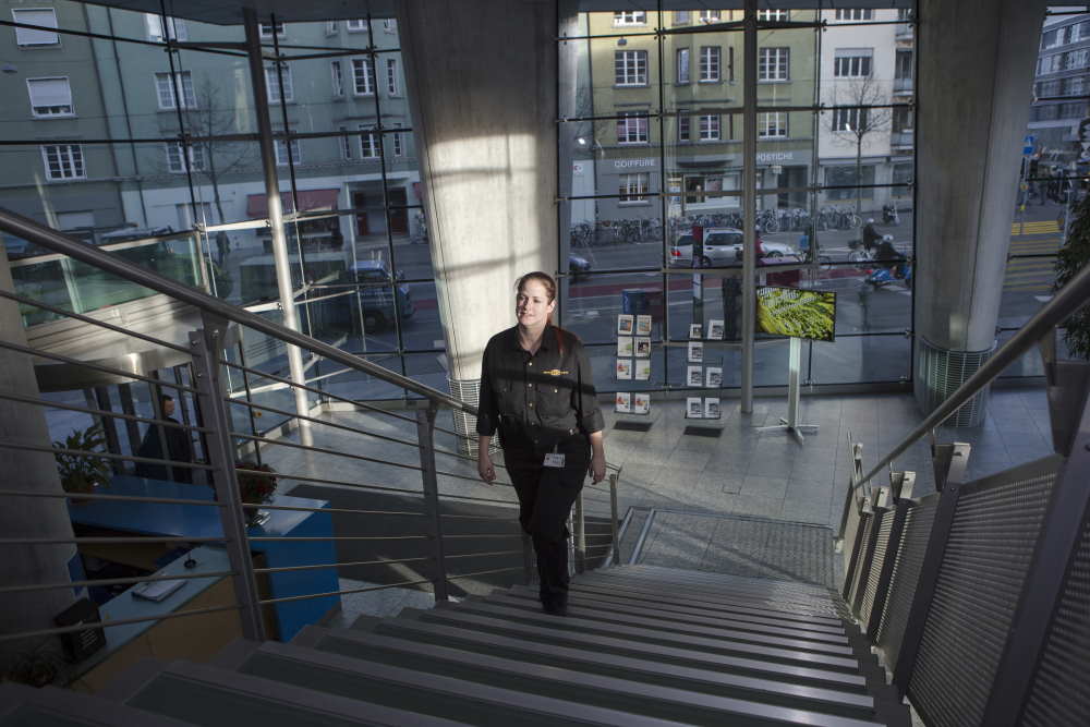 Une agente professionnelle de sécurité monte les escaliers dans un bâtiment de verre