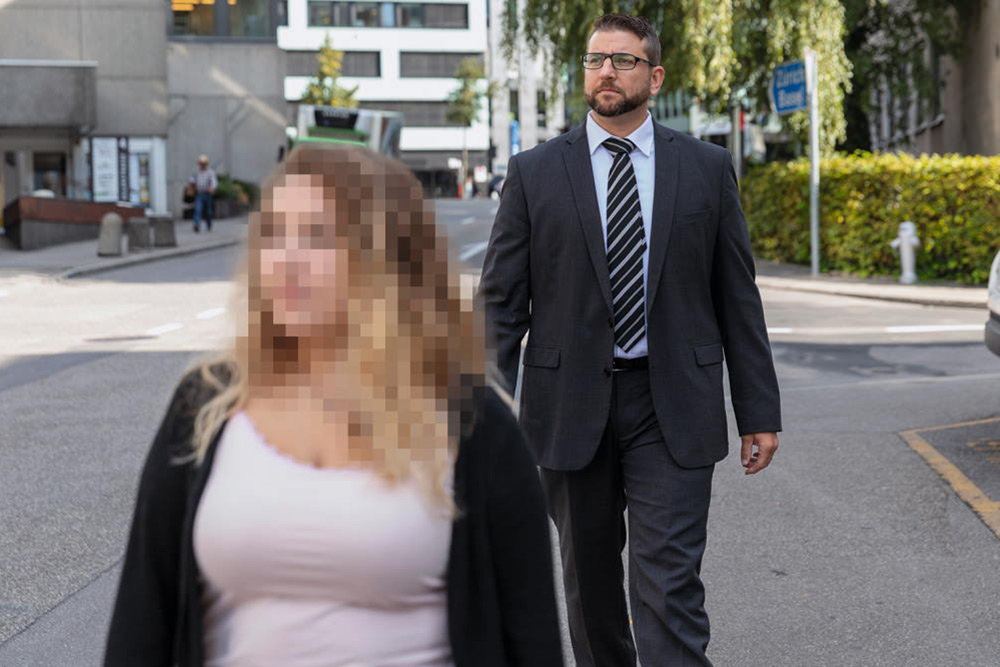 Un homme marche derrière une femme et est attentif à ce qui se passe dans la rue.