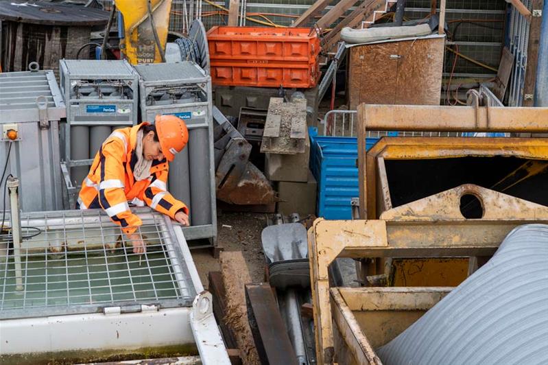 Une femme en tenue de sécurité travaille sur un chantier.