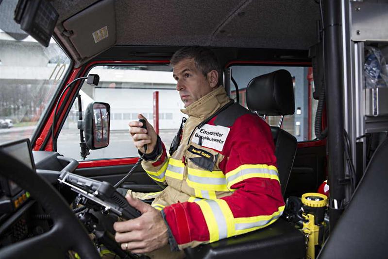 Un sapeur-pompier conduit un camion de pompiers.