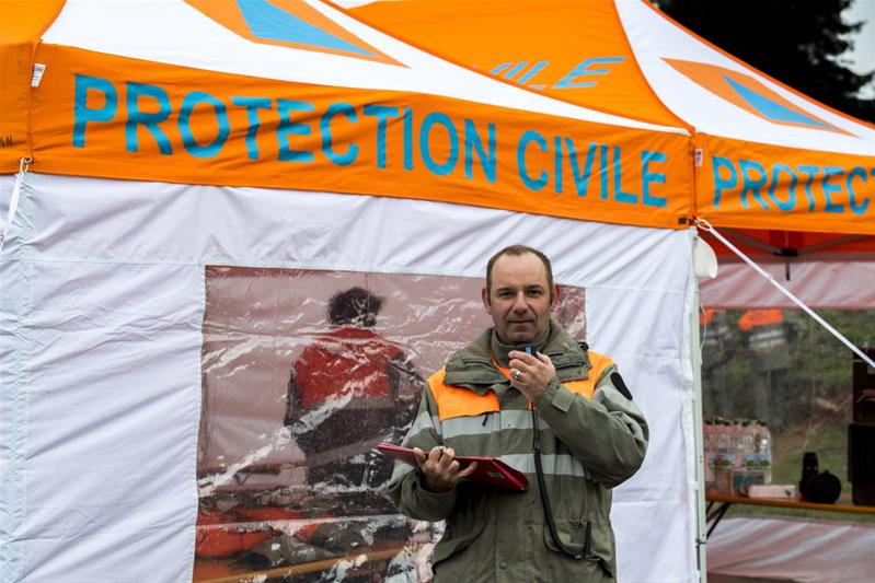 Un homme se tient devant une tente de la protection civile