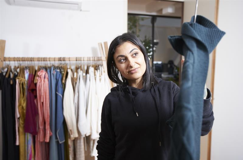 Une femme travaille dans sa boutique de vêtements.