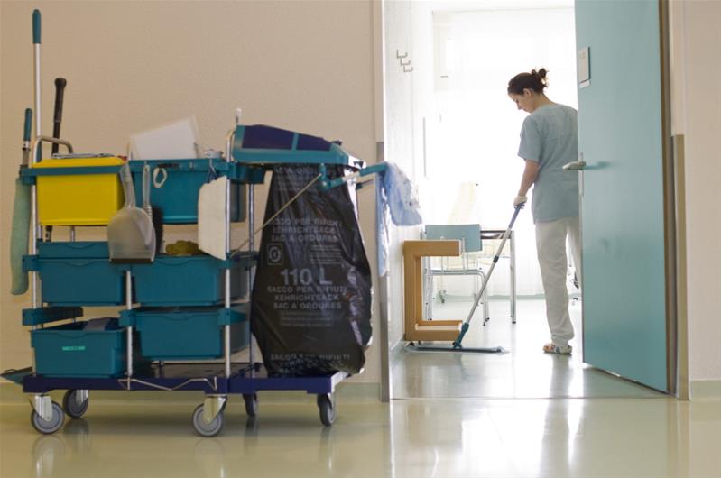 Une femme nettoie le sol d’une pièce.