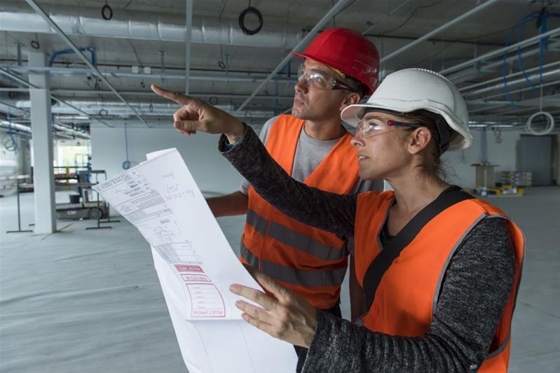 Deux professionnels étudient le lieu sur lequel ils vont devoir opérer.