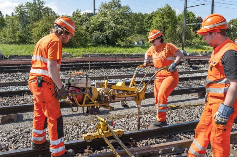 Du personnel de chantier construit et rénove des voies ferrées.