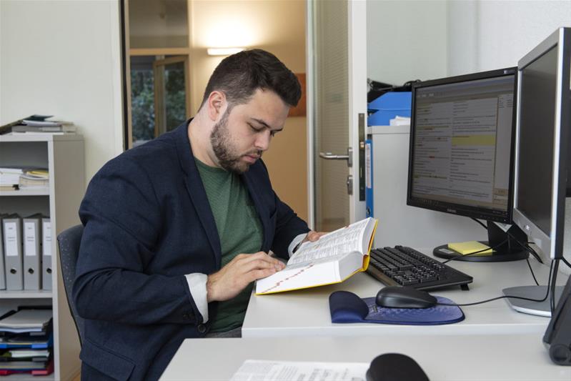 Un homme consulte un dictionnaire.
