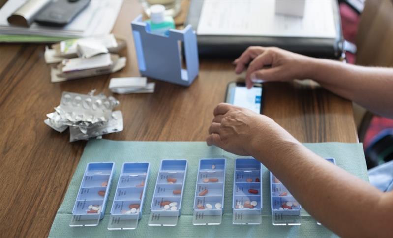 Une personne prépare des piluliers