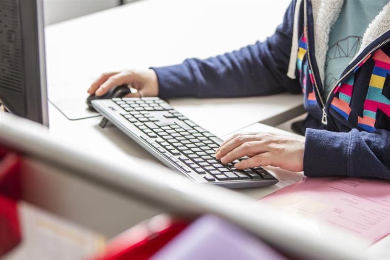 Une personne écrit sur un clavier d'ordinateur