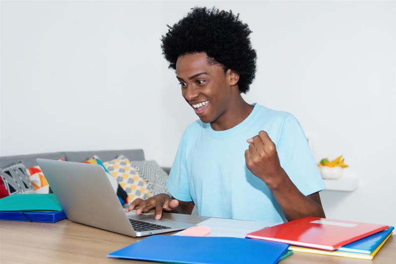 Un adolescent travaille sur son ordinateur.