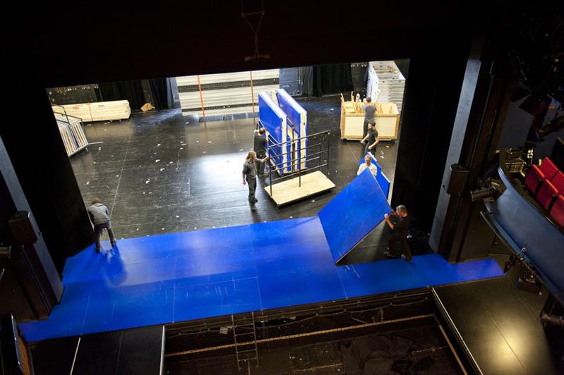 Des professionnels préparent le décor d’une scène.