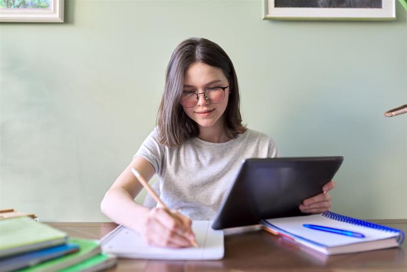 Une jeune fille travaille à son bureau.