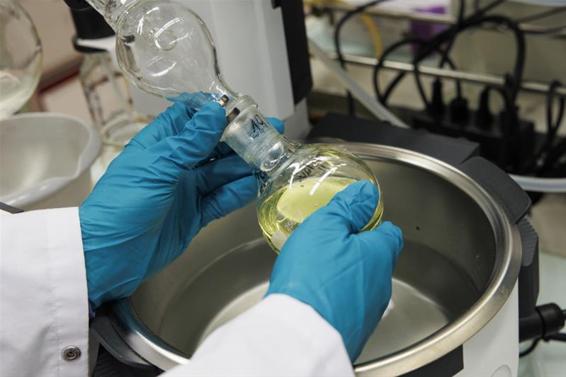 Une personne manipule un liquide dans un laboratoire.