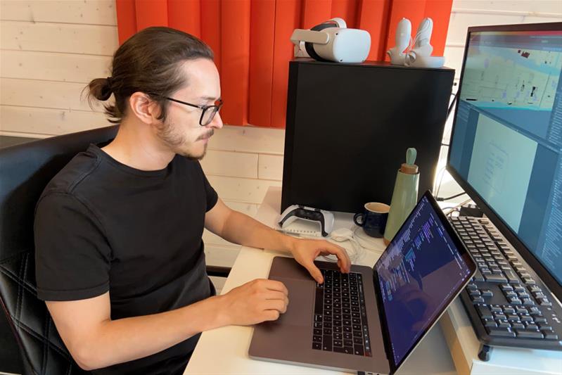Un homme écrit du code informatique à l'ordinateur.
