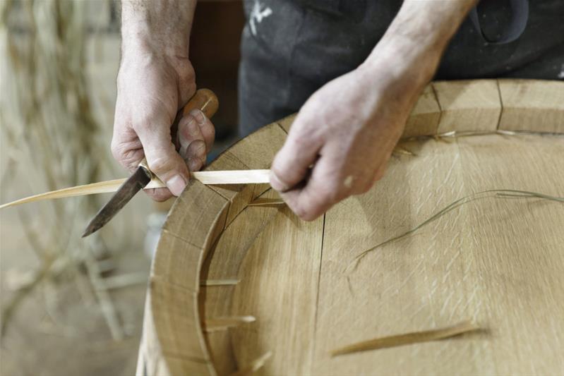 Un artisan fabrique un tonneau.