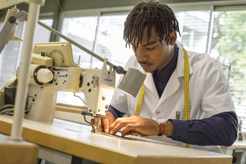 Un apprenti travaille à la machine à coudre.