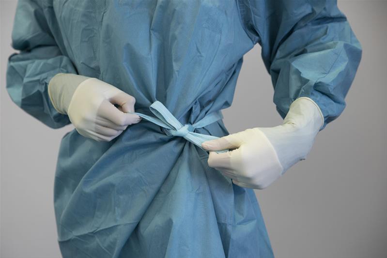 Un médecin noue sa blouse de médecin